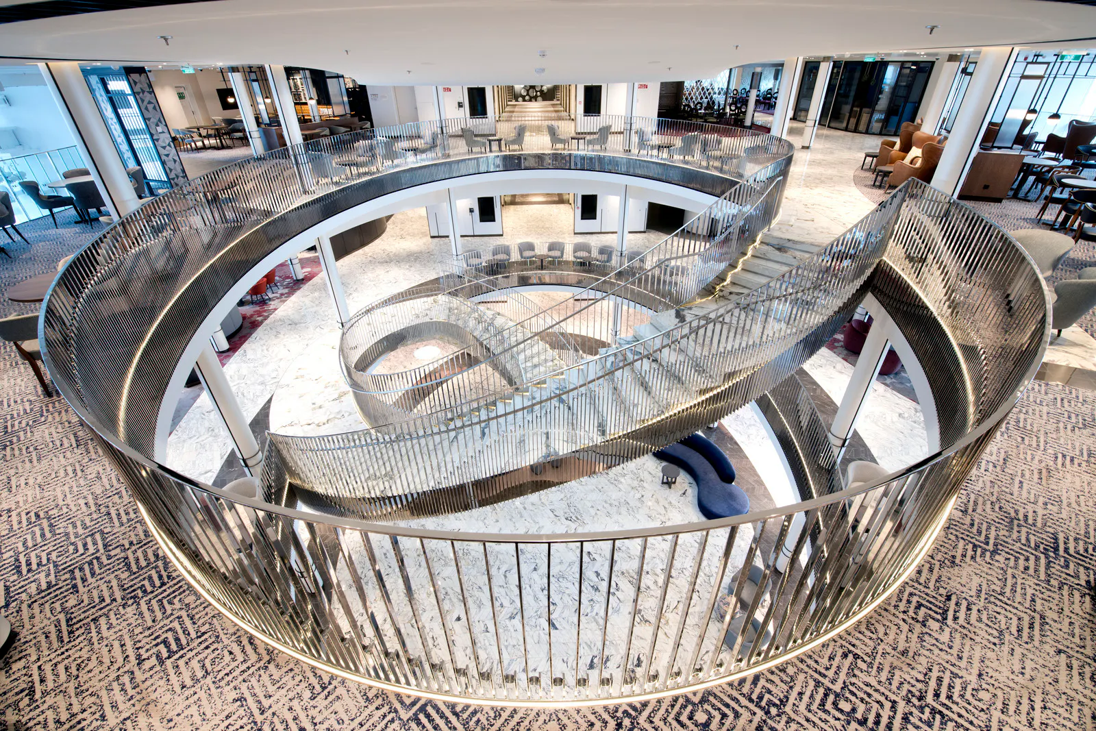 The multi-level atrium on P&O’s Iona, with curved glass balconies sweeping down through the centre.
