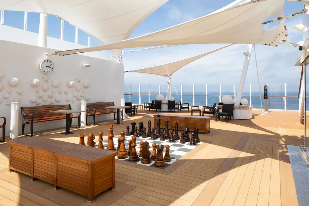 A giant chess set on an open-air deck on P&O’s Iona, with sea views and shaded seating.
