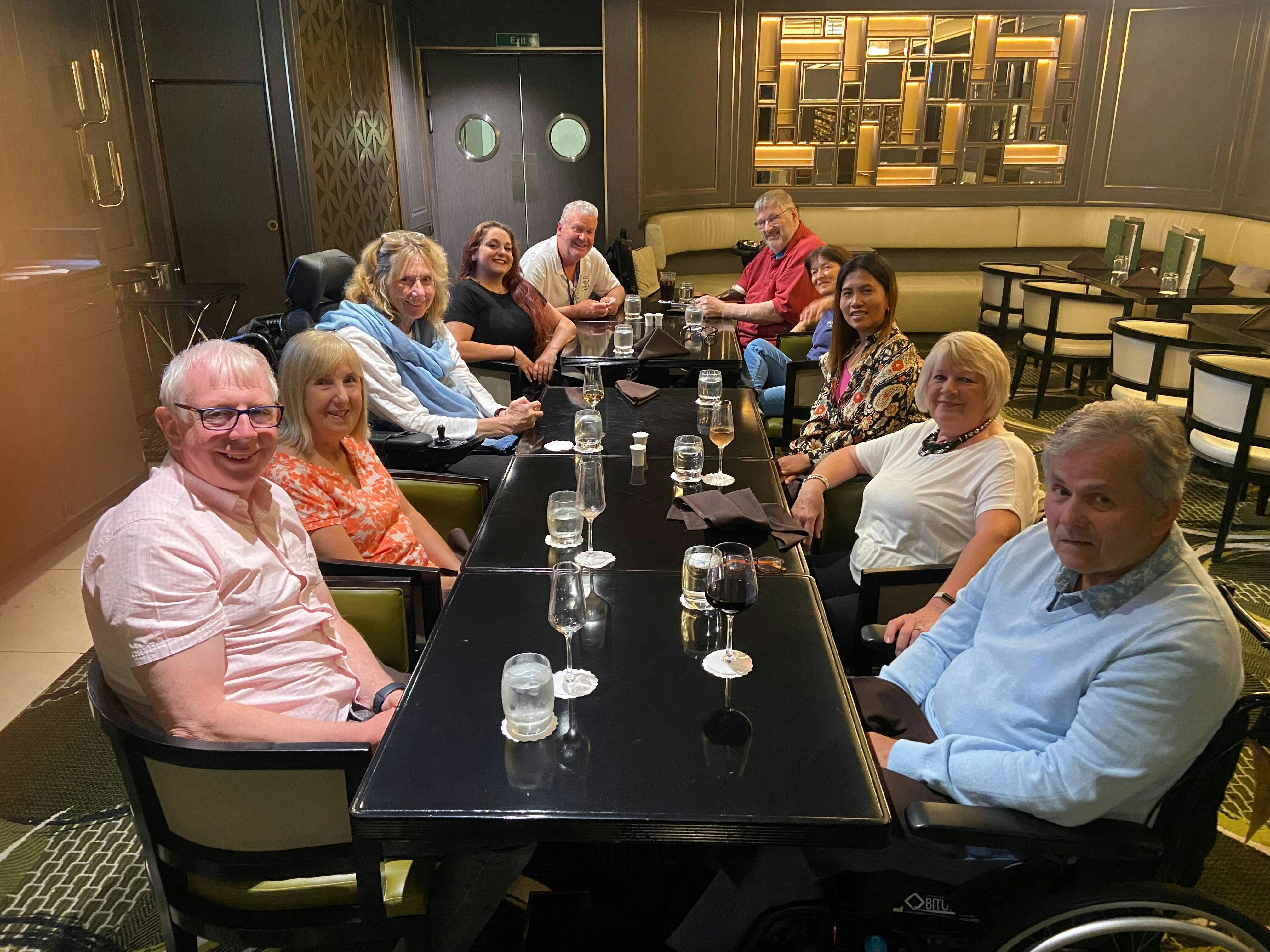 Cruise guests and staff enjoying a meal together on the Britannia