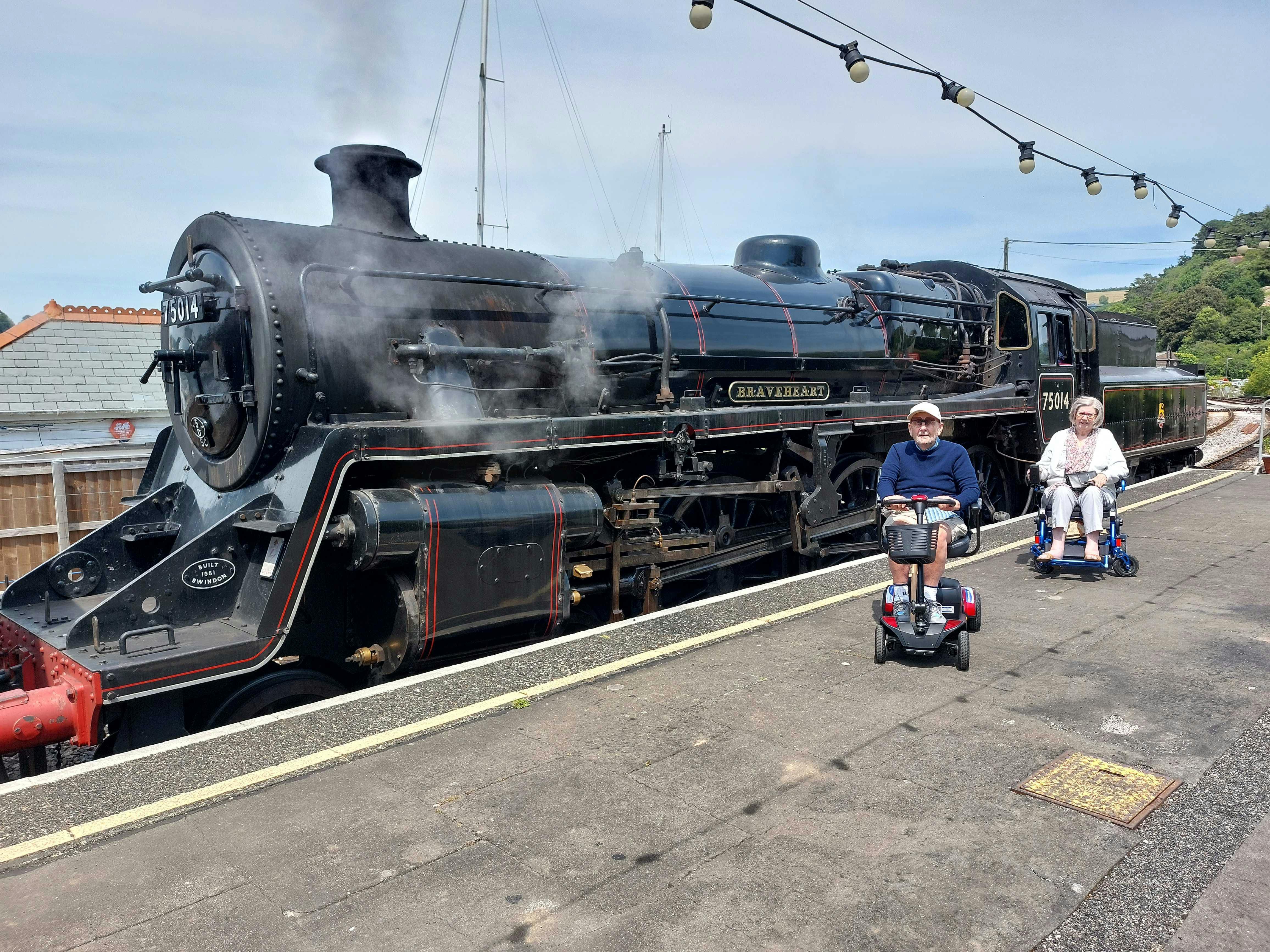 Customer in front of a steam train in Devon