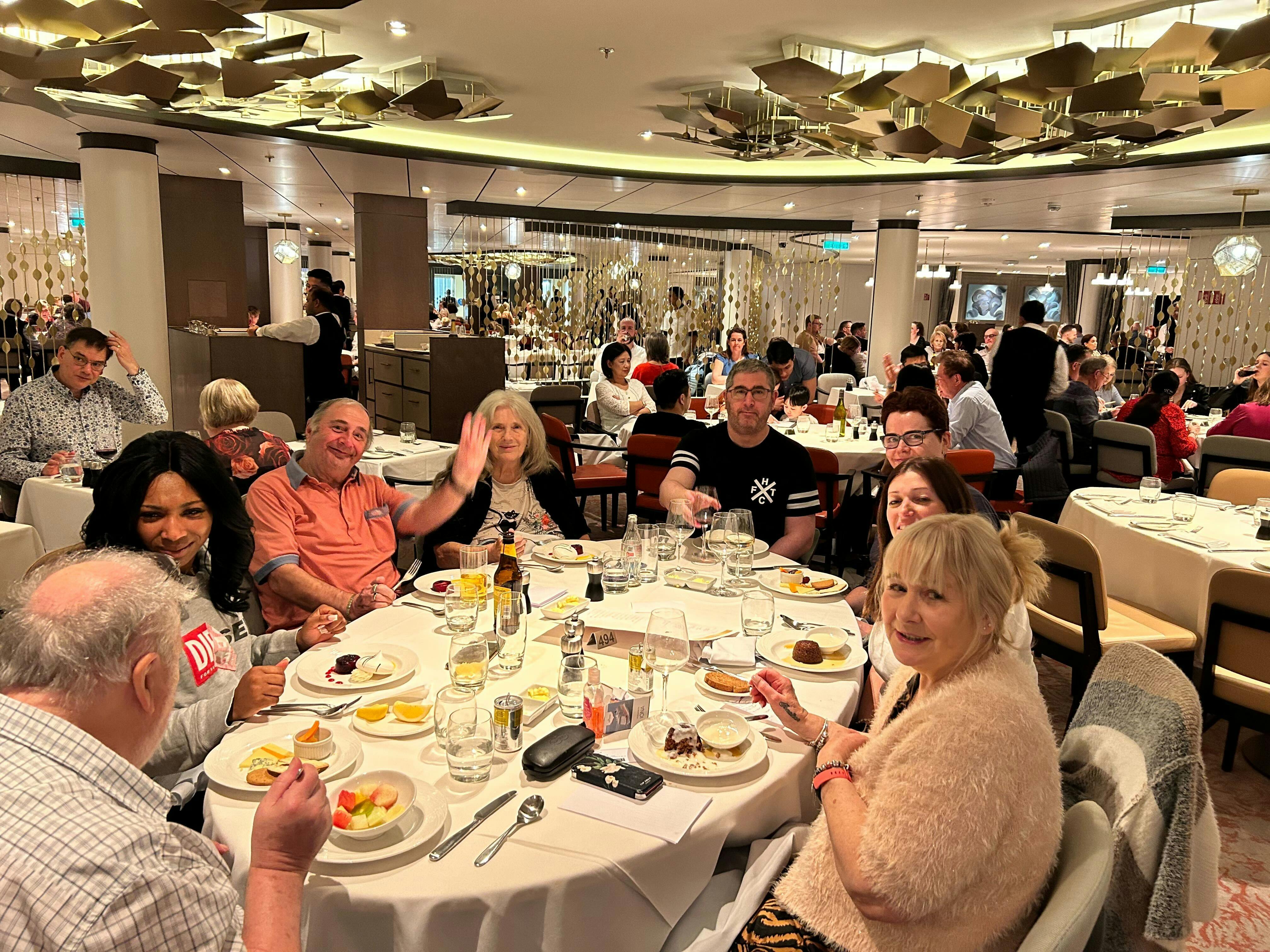 Customers and staff dining  at a restaurant together on board a cruise