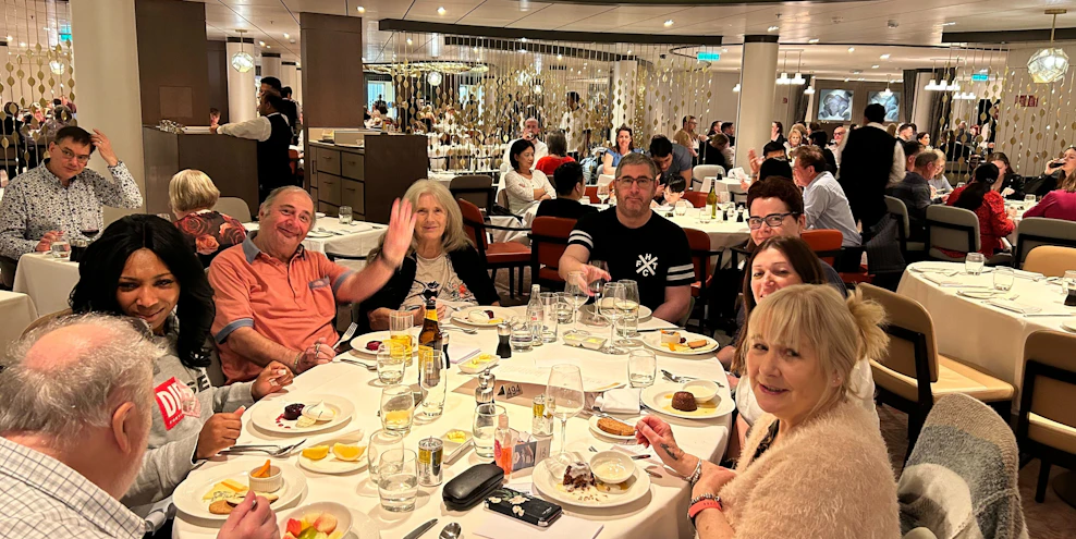 Customers and staff dining  at a restaurant together on board a cruise