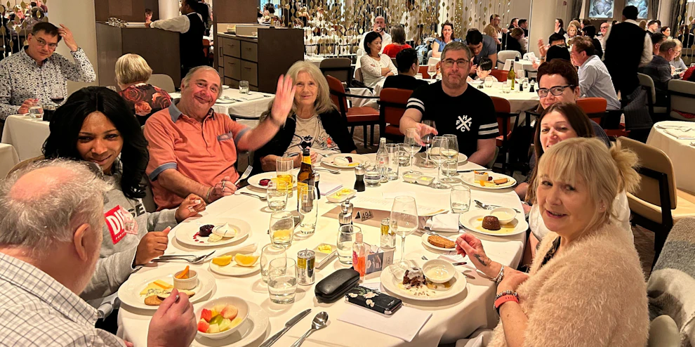 Customers and staff dining  at a restaurant together on board a cruise