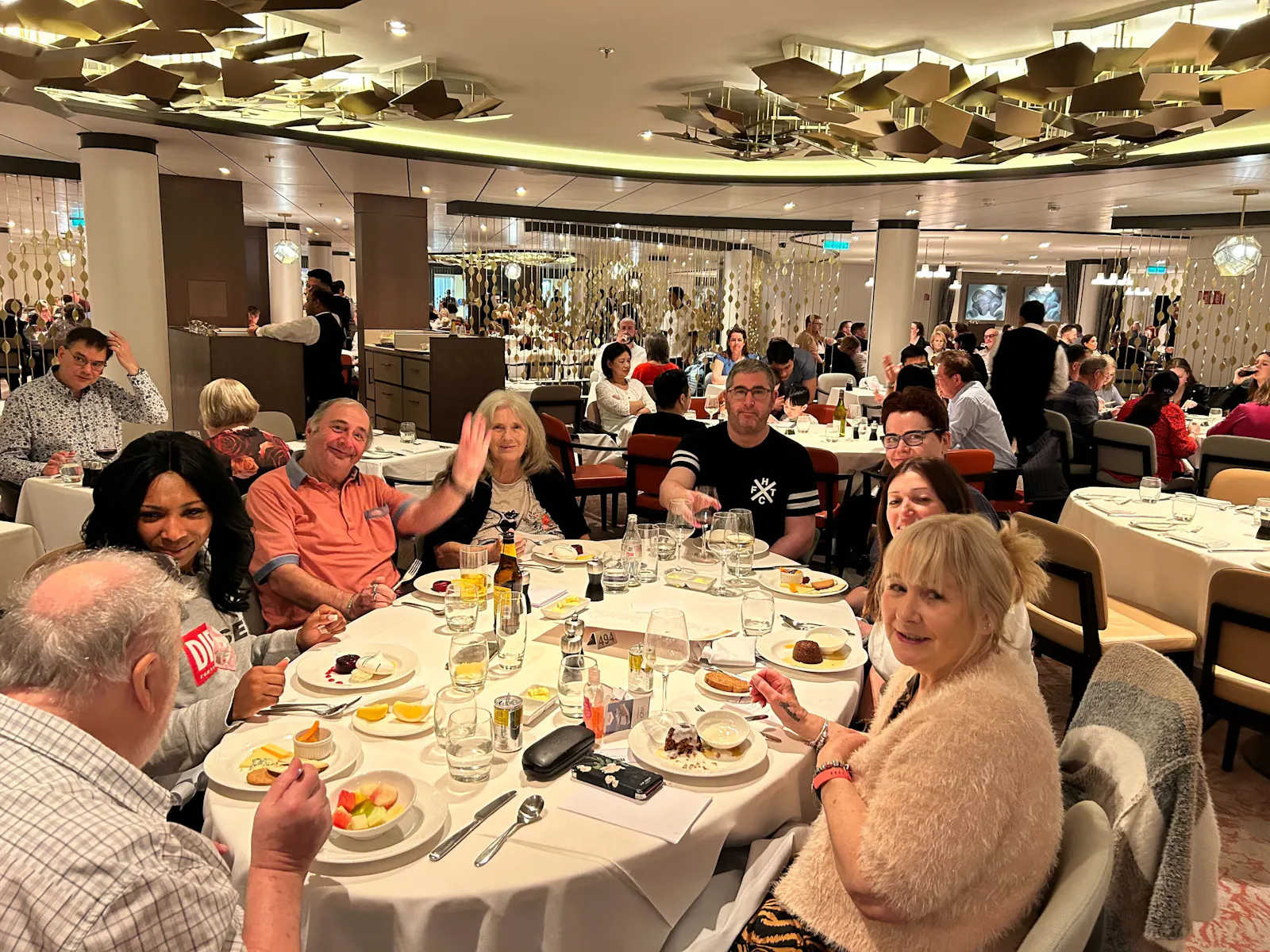 Customers and staff dining  at a restaurant together on board a cruise