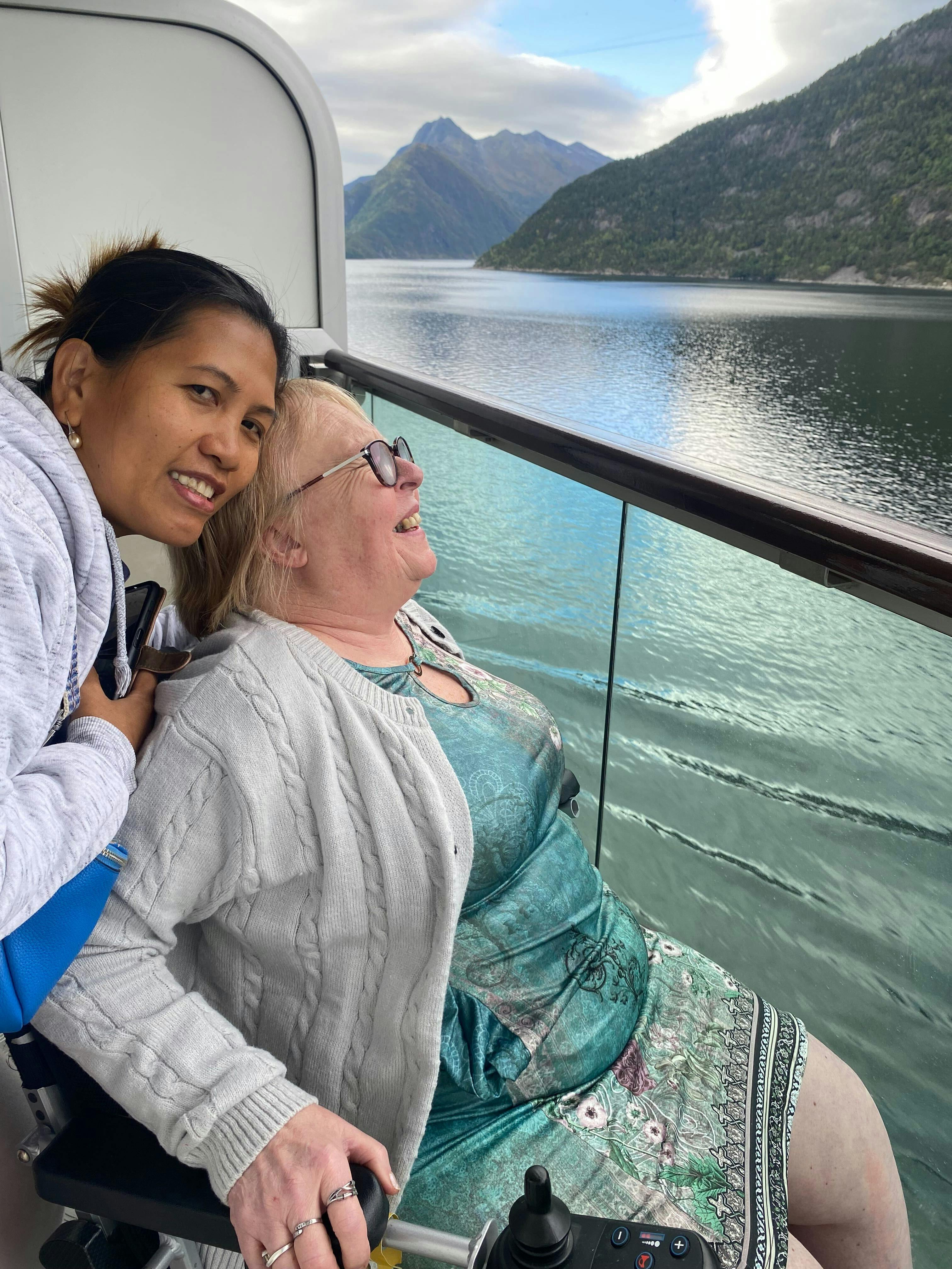 Cruise customer with Limitless staff enjoying the views from cabin of Norway on a cruise