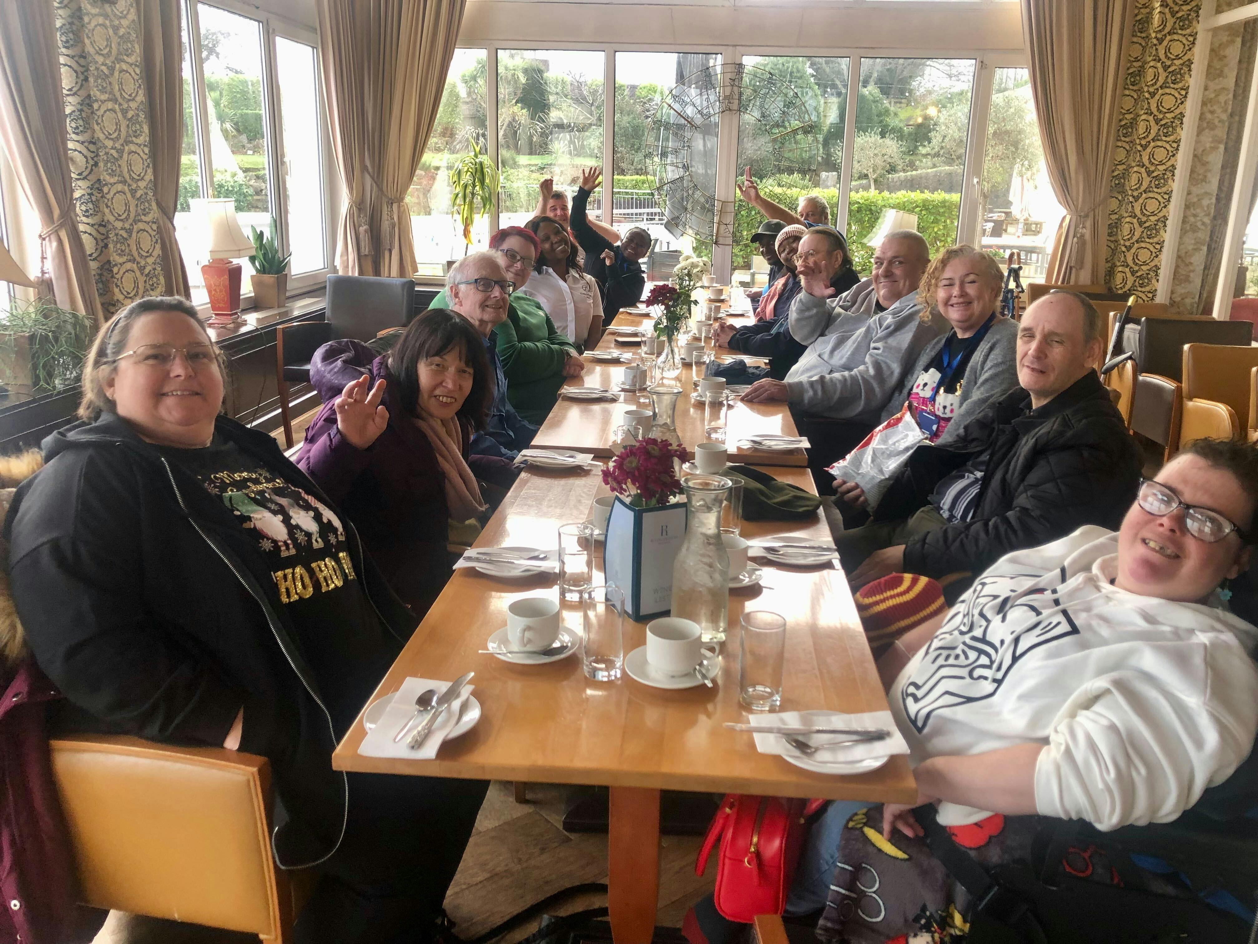 Group photo of guests at table while enjoying cream tea in Devon.