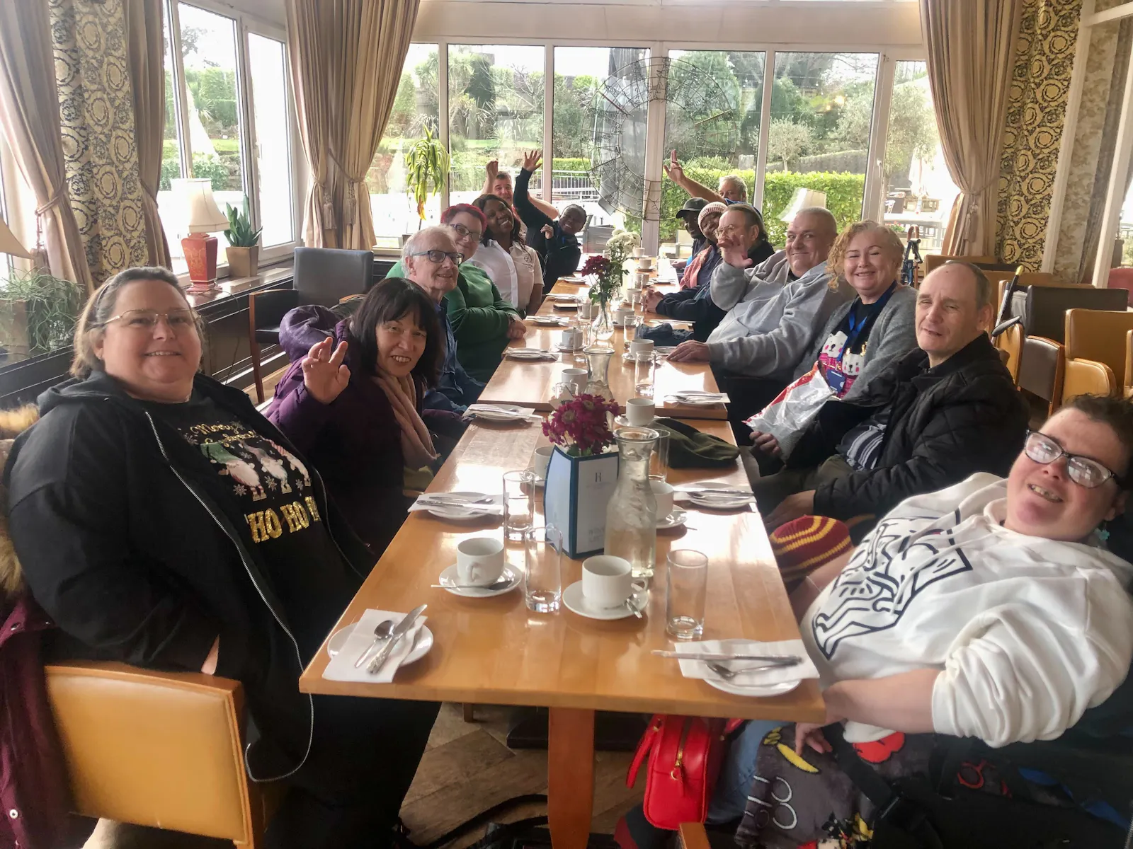 Group photo of guests at table while enjoying cream tea in Devon.