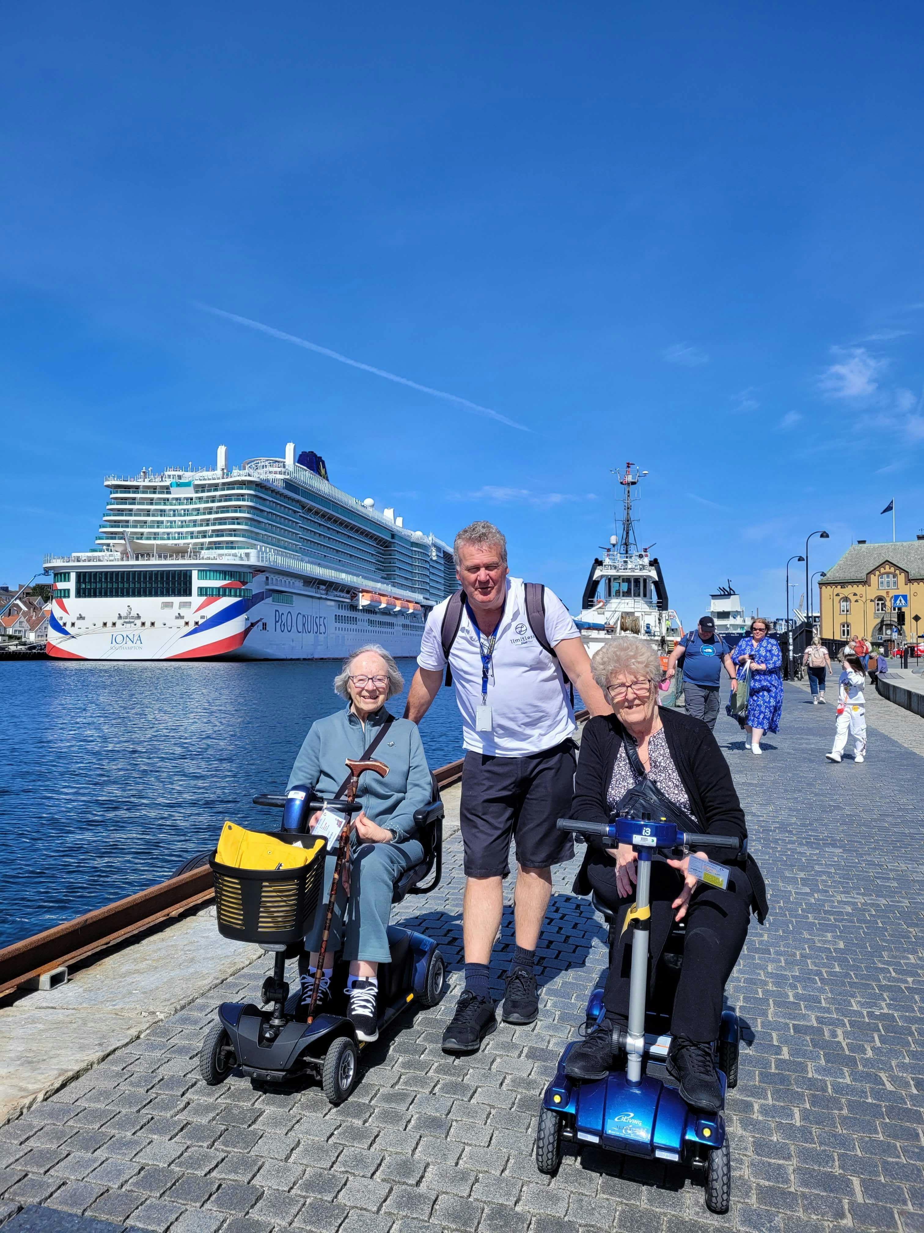 Elderly travellers on a cruise holiday with Limitless staff, P&O Iona in the background